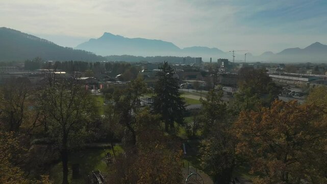 Revealing Drone Shot of Salzburg, Austria on Sunny Misty Autumn Day, Buildings, Parks and Railway