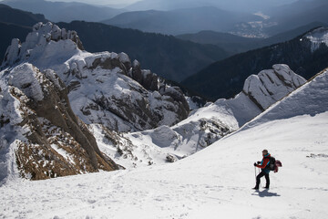 A lone hiker gazing at a majestic, snow-covered mountain peak