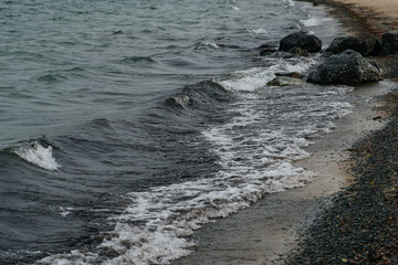 big waves near the shore with pebbles