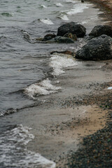 big waves near the shore with pebbles