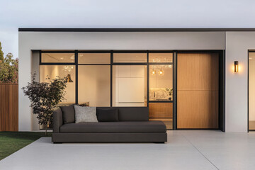 Modern outdoor seating area adjacent to a stylish kitchen at twilight in a contemporary home