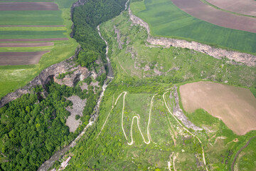 Aerial view of Dzoraget canyon and a road descending to the river on sunny spring day. Yaghdan...