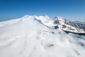 Aerial view of Mount Aragats cowered with snow on sunny spring day. Armenia.