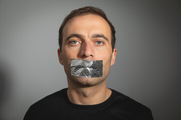 Caucasian man with tape on mouth.