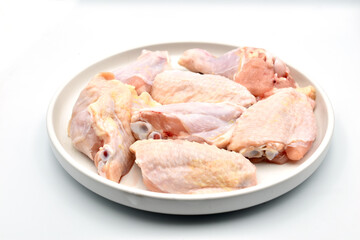 Chicken meat lies on a clay plate, which stands on a white background.