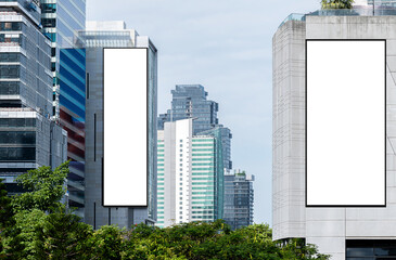 Two white mock up vertical large LED display billboard on tower building with blue sky background...