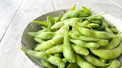 Edamame beans in ceramic bowl, soybeans, selective focus.
