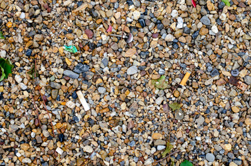 公園内の砂利に紛れるポイ捨てされたゴミたち