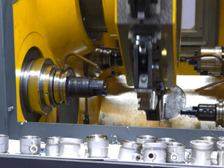 CNC machine cutting thread on pipe fitting.