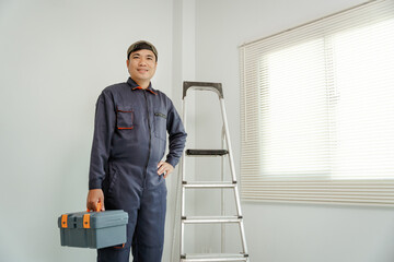 A professional installer in uniform with his toolbox, modern blinds behind him, sleek design, bright and professional look.