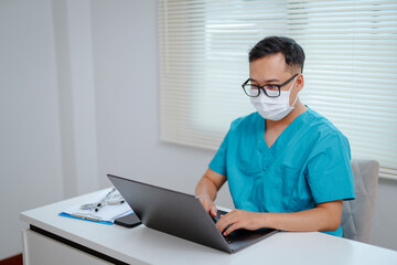 Asian doctor's hand with stethoscope next to laptop, signifying medical analysis and modern technology, clean and professional.