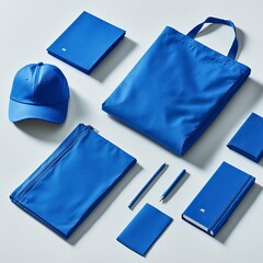Naklejka premium A stock image of a combination of merchandise including a t-shirt, tote bag, cap, and notebook, all royal blue with white designs, generative ai