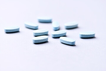 Multivitamin tablets on bright paper background. Close up. Copy space.