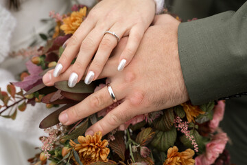 Close-up of Bride and Groom’s Hands with Wedding Rings and Bouquet