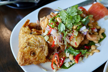 Deep fried Tilapia fish with sweet chili sauce in plate