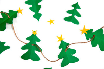 Christmas tree paper cutout craft with string against white background