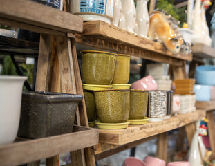 Colorful ceramic pots on wooden shelves in a shop, vintage style