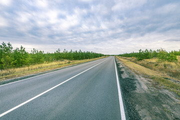 A long road with a few trees in the background