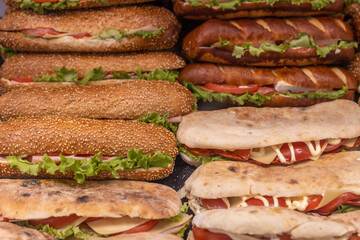 Variety of sandwiches are displayed on a table, including some with lettuce