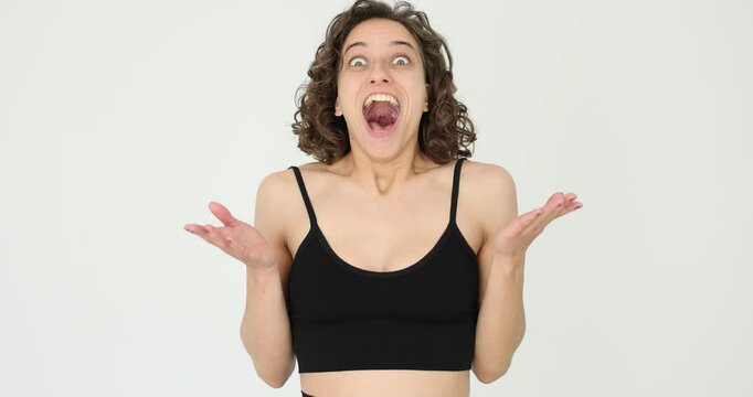 Woman expresses surprise and open mouth in white studio