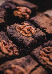 Chocolate brownie cake with walnuts on top, cut into square pieces, homemade sweet chocolate dessert, close up
