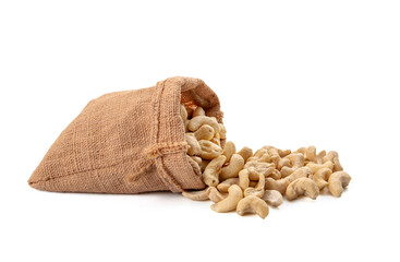 Dried bean, cashew nuts spilled out of sack isolated on white background. Cashews are commonly eaten snack and are also used ingredient in cooking.