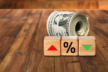 Wooden blocks with percentage sign, arrow and dollar banknotes