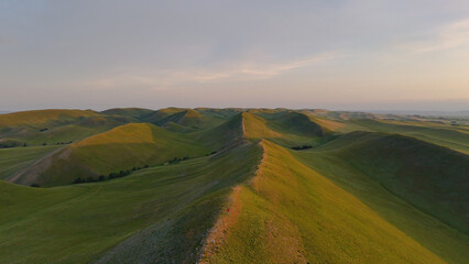 Obraz premium flying over textured green mountains in the Orenburg region