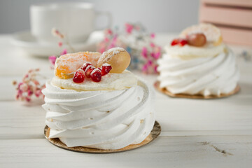 Meringue dessert with fruits. White dessert on a light table.