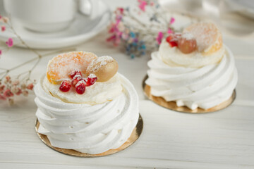 Meringue dessert with fruits. White dessert on a light table.