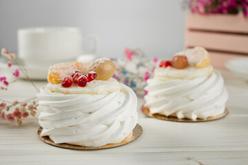 Meringue dessert with fruits. White dessert on a light table.