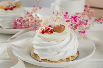 Meringue dessert with fruits. White dessert on a light table.