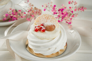 Meringue dessert with fruits. White dessert on a light table.