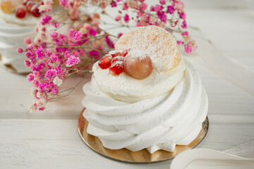 Meringue dessert with fruits. White dessert on a light table.