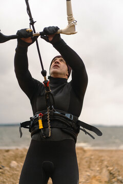 Middle aged man kite surfing, holding a bar in his hands