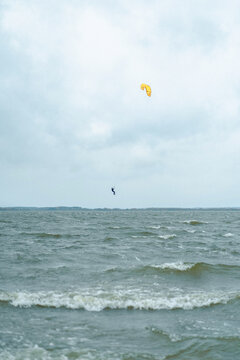 A man kiteboarding in the lake keys jumps out of the water
