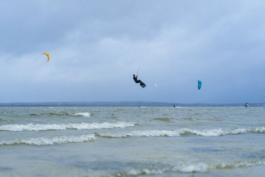 A man kiteboarding in the lake keys jumps out of the water