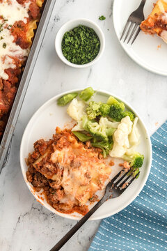 Lasagna roll-up served on a plate with steamed vegetables