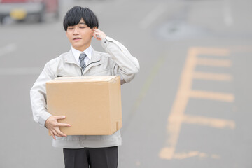 段ボールと作業着男性