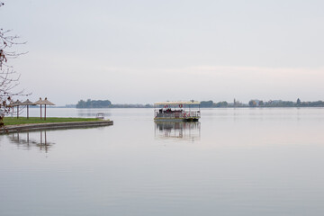 Obraz premium A tranquil lake scene with a floating dock and overcast sky evokes serenity and peaceful solitude, ideal for reflecting nature's calmness