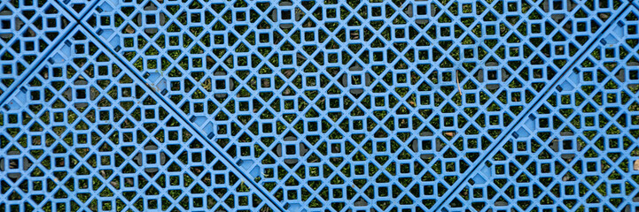 Close-up of a blue lattice pattern on artificial grass, symbolizing concepts of structure and modern architecture design