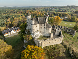 Naklejka premium Aerial drone view of Bobolice Castle in autumn.Old medieval fortress, royal castle in the village of Bobolice, Poland.Strongholds Eagles Nests in Polish Jurassic Highland.Limestone rock castle ruins.