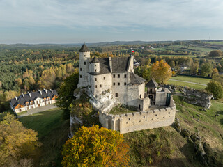 Obraz premium Aerial drone view of Bobolice Castle in autumn.Old medieval fortress, royal castle in the village of Bobolice, Poland.Strongholds Eagles Nests in Polish Jurassic Highland.Limestone rock castle ruins.