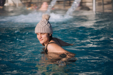 Woman Relaxing in a Heated Outdoor Pool with Winter Backdrop