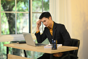 Serious businessman contemplating solutions to business problems