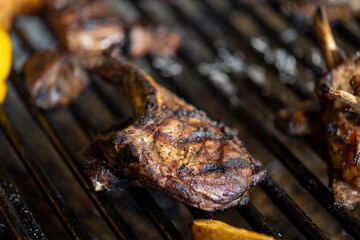 roasted meat and vegetables on the grill with flames and vegetables, close up