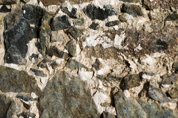 Rough textured closeup of rocky stone wall. Stony natural stone texture. Grunge background.