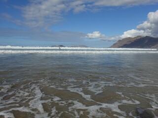 Serene beach with distant mountains.