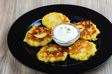 A plate of pancakes with sour cream, mashed potatoes, beans. food that is delicious and. round potato concept. a plate of pancakes with sour cream, mashed potatoes, and beans. food that is delicious.