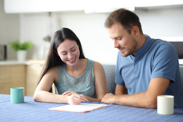 Obraz premium Happy interracial roommates or couple signing contract